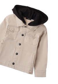 Chaqueta de mezclilla beige con capucha de forro polar negra. Cuenta con dos bolsillos en el pecho, cierre frontal con botones y un parche de logo en el lado inferior.
