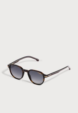 Ochelari de soare maro model tartă cu lentile pătrate în degrade închișori și brațe subțiri negre, deschiși, așezați pe o suprafață deschisă la culoare.