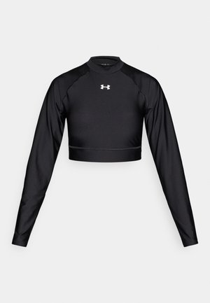 Crop top noir à manches longues en tissu extensible avec un col rond, doté d'un logo blanc sur la poitrine et de coutures plates.