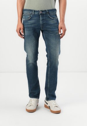 Dunkelblaue Jeans mit geradem Schnitt, subtilem Used-Look, Fünf-Taschen-Design und einem taillierten Bund mit roten Akzenten.