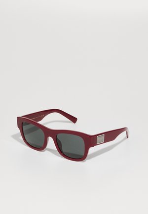 Óculos de sol de plástico cor bordô com lentes escuras. Forma quadrada com hastes elegantes que apresentam um acabamento metálico na lateral.