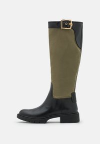 Wysokie buty z czarną skórzaną dolną częścią oraz oliwkowo-zieloną górną częścią z tkaniny. Posiadają złotą klamrę na górze.