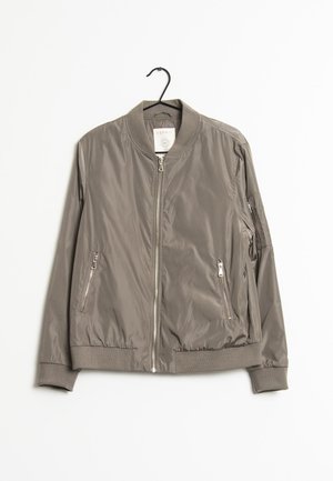 Lichte, grijze bomberjack met rits aan de voorkant, ribbelkraag en twee zijzakken met rits. Gladde textuur met elastische manchetten en zoom.