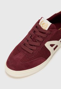 sneaker bordeaux con tomaia in mesh e suede, suola color crema, allacciatura a sei occhielli e linguetta decorata con logo.