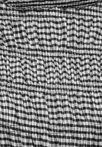 Țesătură texturată alb-negru cu dungi orizontale neregulate și secțiuni adunate, strânse, creând un model ondulat.