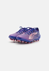 Geschenkde voetbalschoenen in blauw en roze, met een gestructureerde bovenkant, gebogen ontwerp en rubberen noppen voor grip op grasoppervlakken.