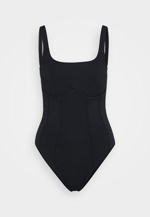 Zwarte badpak met brede banden, vierkante halslijn en gestructureerde buste. Glad materiaal met contourvormige zijnaad. Geen zichtbare hardware.