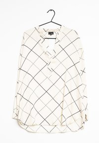 Langærmet bluse i off-white stof med et sort rutemønster, der har en v-halsudskæring og en kant, som dypper let bagpå.