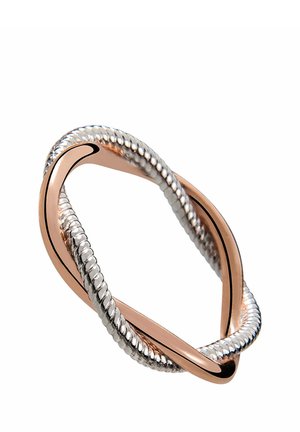 Anillos de metal torcido entrelazados de oro rosa y plata que forman un lazo elegante y continuo sobre fondo blanco.