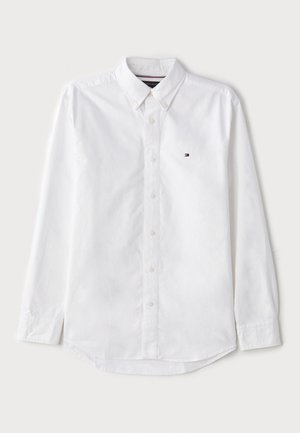 Cămașă albă cu mâneci lungi, cu guler clasic, fabricată din bumbac, având un logo subtil pe piept și o margine rotunjită.