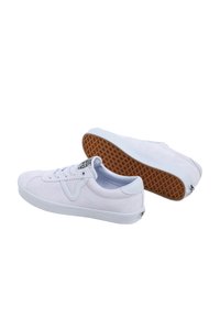 White suede sneakers with a low-top design, featuring round laces, a textured gum rubber sole, and a subtle logo tag near the heel.