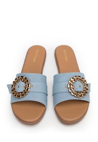Le ciabatte in denim blu presentano una larga fascia decorata con un accentuato cerchio dorato, una suola marrone e una texture morbida per un comfort informale.