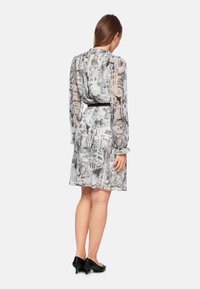 Transparente Kleid mit einem monochromen Stadtlandschaftsdruk, langen Ärmeln, Rüschensaum und einem schwarzen Taillengürtel, abgeschlossen mit einem ausgestellten Saum.