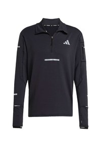 Pull-over de sport noir avec une fermeture éclair quart, un tissu texturé, des accents réfléchissants et une poche à zip sur la manche. Doté d'un col haut.