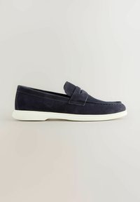 Tumesinised seemisnahast mokassiinsusse valge kummist tallaga, libistatav stiil ja klassikalise rahavöökesega, esitletud neutraalse tausta ees.