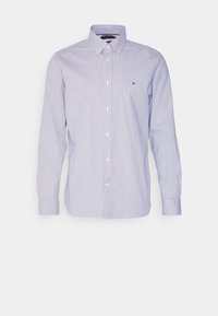 Chemise boutonnée à rayures verticales bleu et blanc, à manches longues, col classique, avec un petit logo sur la poche poitrine gauche. Matière en coton.