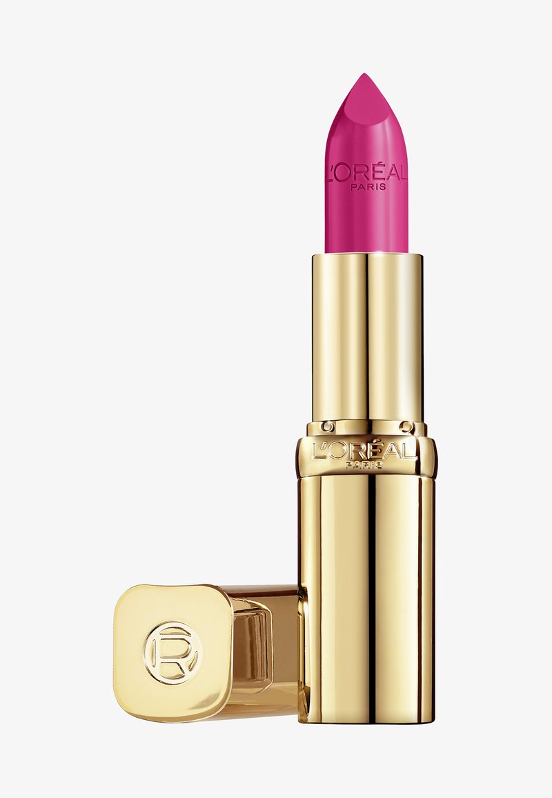 Rossetto rosa in un tubo metallico dorato, con punta appuntita e logo in rilievo. Il tappo è quadrato e presenta un design circolare in rilievo.