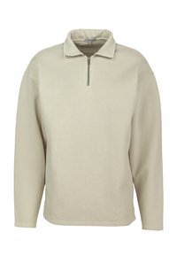 Béžový pulovr s dlouhým rukávem a stojacím límcem, s předním čtvrtinovým zipem, vyrobený z měkkého materiálu.