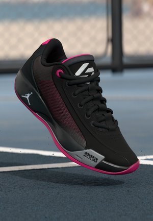 Black athletic shoe with mesh detailing, pink accents, and a metallic silver logo. Features a padded collar and a textured sole for grip.