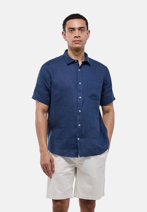 Chemise en lin bleu marine à manches courtes, avec un col boutonné et une poche poitrine. Dotée de boutons blancs et d'un design décontracté.