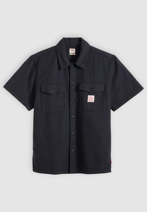 Zwart overhemdbloesje met korte mouwen en knopen, voorzien van twee borstzakken, waarvan één met een klein wit-rood Levi's-label.