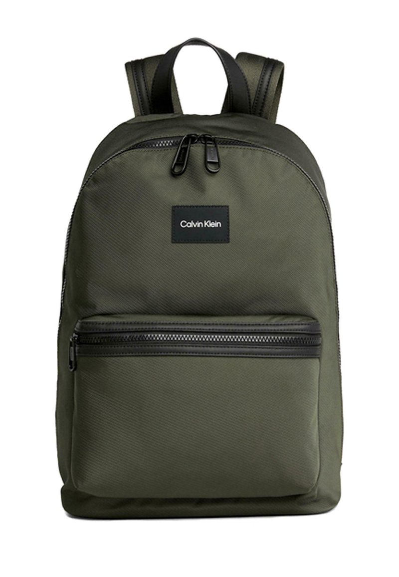 Zaino in nylon verde con cerniere nere, dotato di una tasca frontale e un'etichetta rettangolare. Spallacci imbottiti per il comfort.