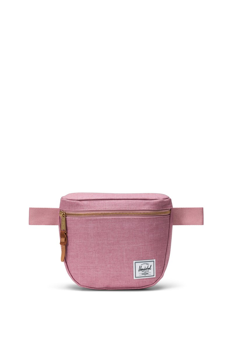 Rosa tygpåse med rundad form, guldfärgad dragkedja och draghandtag i brunt läder. Har en vit logo-patch på framsidan och ett sidofäste.