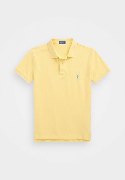 Sárga polo póló, pamutból készült, hegyes gallérral, rövid ujjakkal és egy kis kék hímzett logóval a bal mellen.