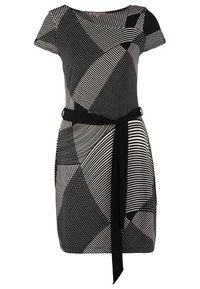 Svart och vit klänning med abstrakta geometriska mönster, korta ärmar, en figurnära midja med ett svart bälte och en rundad halsringning.