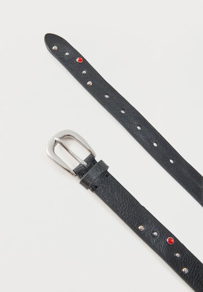 Μαύρη δερμάτινη ζώνη με ασημένια αγκράφα και μεταλλικές καρφίτσες, συμπεριλαμβανομένης μιας κόκκινης καρφίτσας, τοποθετημένη επίπεδα σε ανοιχτή επιφάνεια.