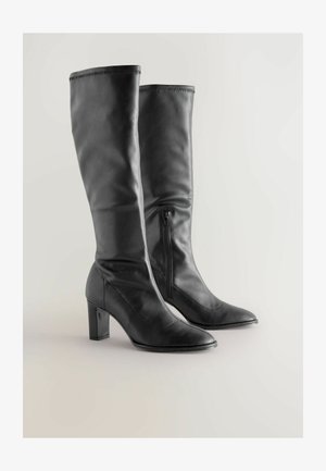 Knöchelhohe schwarze Lederstiefel mit spitzer Zehenpartie, seitlichem Reißverschluss und Blockabsatz. Glatte Textur mit gesteppten Details.