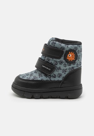 Bottes pour tout-petits en bleu et noir avec une tige texturée présentant un motif ludique. Deux bandes Velcro noires et un accent orange rond complètent le design.