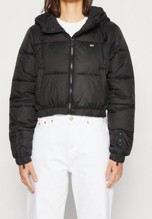 Zwarte cropped pufferjack met capuchon, voorzien van ritssluitingen en elastische manchetten. Glad textuur, lichtgewicht materiaal.