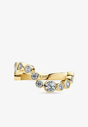 Guld ring med flere runde diamanter i forskellige størrelser sat i et forskudt mønster rundt om båndet.