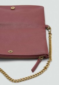 Clutch in pelle bordeaux con finitura texturizzata, zip dorata e tracolla in catena. Dotata di chiusure a scatto e di una zip laterale.