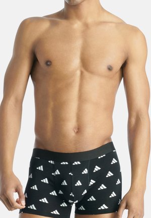 Schwarze Boxershorts mit einem geometrischen weißen Muster, ausgestattet mit einem weichen Bund und einer engen Passform. Der Stoff wirkt glatt und elastisch.