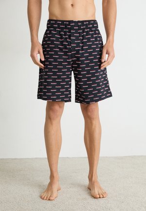 Schwarze Schwimmshorts mit wiederholtem "HUGO" Logo in Rot und Weiß. Mit elastischem Bund und einer Länge bis zur Mitte des Oberschenkels. Weicher Stoff.
