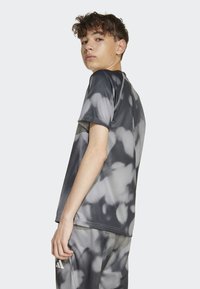 Šedé a čierne tričko s moderným batikovaním, krátke rukávy, ľahký materiál, určené na aktívne nosenie, hladká textúra, jemné detaily švov.