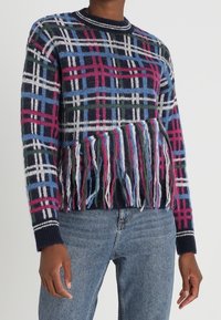 Strickpullover mit einem Karomuster in Marineblau, Grün, Blau und Rosa, mit fransigem Saum und gerippten Bündchen.