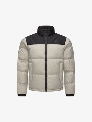 Puhasti kaput s bež tijelom i crnim gornjim dijelom, s visokim ovratnikom, dugim rukavima i prednjim patentnim zatvaračem. Tekstuirana tkanina s quilted dizajnom.