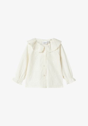 Blusa per bebé a maniche lunghe in crema con colletto Peter Pan scollato a onda, pattern floreali ricamati, chiusura anteriore con bottoni e polsini elasticizzati con volant.