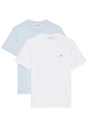 Két egyszerű kerek nyakú póló, az egyik fehér, kis CK logóval a mellkasán, a másik világoskék, a fehér póló mögött rétegezve.