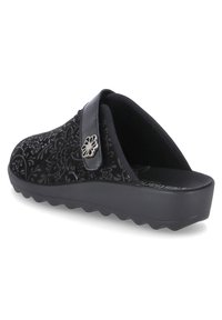 Black slip-on clogs with floral embossed pattern, glossy black strap, and a textured rubber sole for grip. Features silver flower accent.