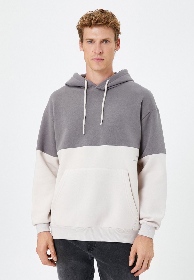 Szary i kremowy, kolorowy blokowany sweatshirts z kapturem, posiadający przednią kieszeń, regulowany kaptur i ściągacze przy mankietach. Wykonany z miękkiego, teksturowanego materiału.