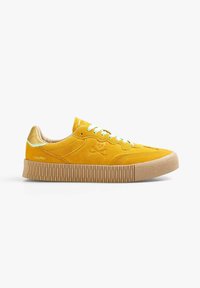 Sneaker giallo in suede con suola in gomma beige, presenta lacci verdi e un logo impresso sul lato. Punta rotonda e dettagli testurizzati.