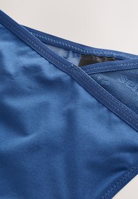 Tejido de baño azul con textura suave, que presenta un panel de malla y ribete elástico en el escote, bordes cosidos y un brillo sutil.