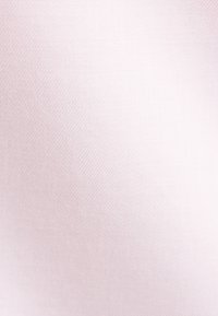 Tissu rose clair doux avec une texture lisse et finement tissée, présentant de légères lignes diagonales.