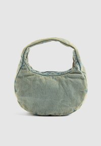 Rondvormige handtas van lichtblauwe denim. Heeft een korte, gevoerde handgreep en een zachte, textuur oppervlakte. Met ritsopening.