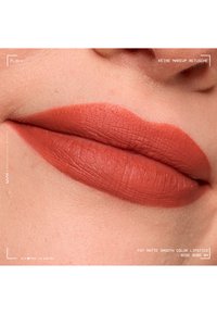 Nahaufnahme von Lippen mit glattem, mattem, gedämpftem rosaroten Lippenstift, die die natürliche Hautstruktur ohne Make-up-Retusche zeigen.