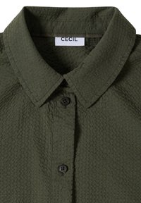 Mørkegrøn tekstureret skjorte med spids krave og to sorte knapper synlige på den forreste stolpelukning.